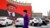 MUSLIMS-CAMPS/CHINA -- An ethnic Uighur woman walks in front of a giant screen with a picture of Chinese President Xi Jinping in the main city square in Kashgar in Xinjiang Uighur Autonomous Region, China September 6, 2018. 