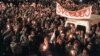 Thousands of people gather under a banner reading "Liberty" 