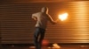 U.K. --A masked nationalist throws a Molotov cocktail at the police on July 14, 2010 during the third night of Nationalist rioting in Belfast.